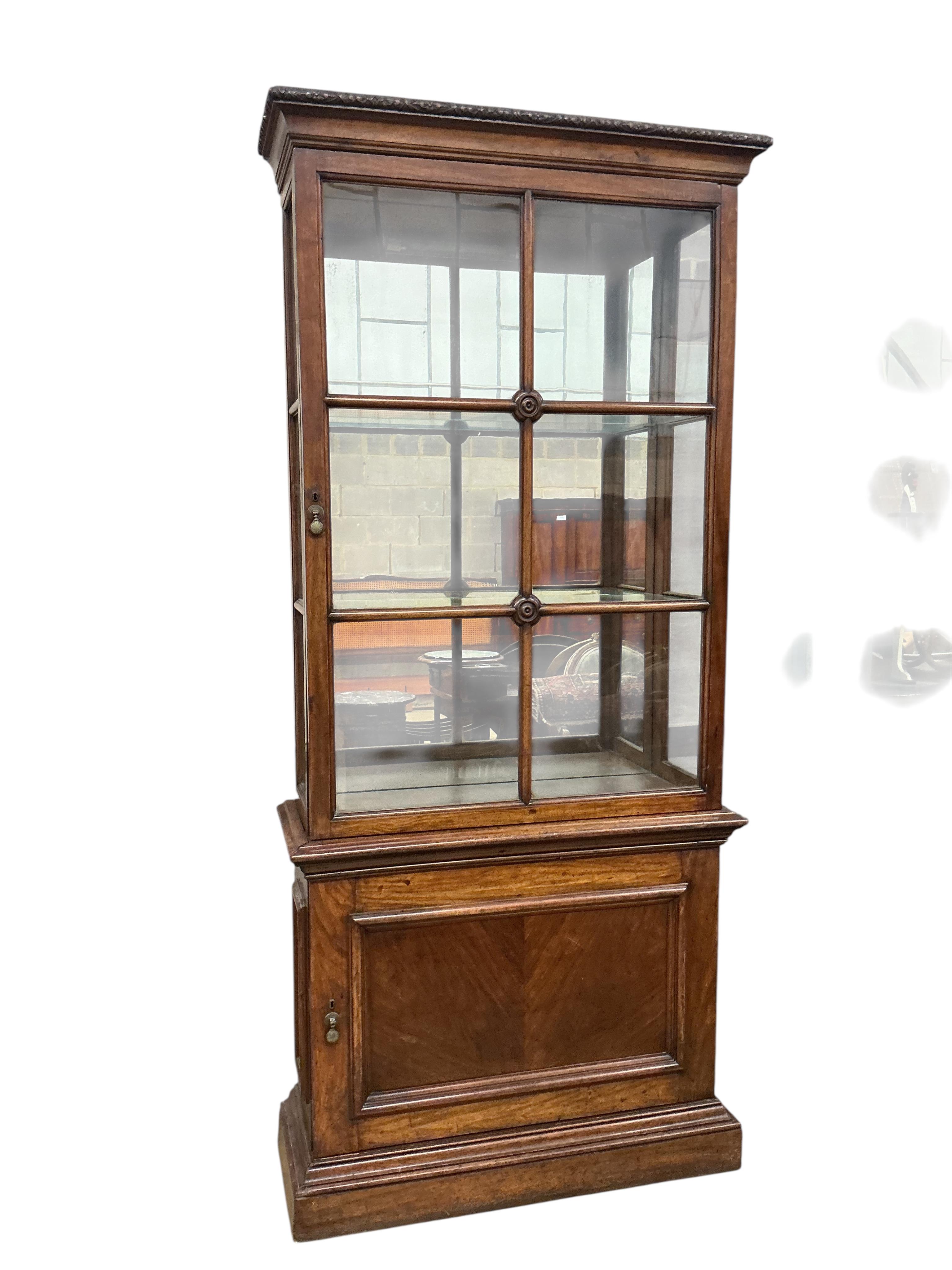 A pair of 1930's walnut vitrines, with single bar glazed doors over single panelled doors, on plinth feet, width 94cm, depth 35cm, height 212cm